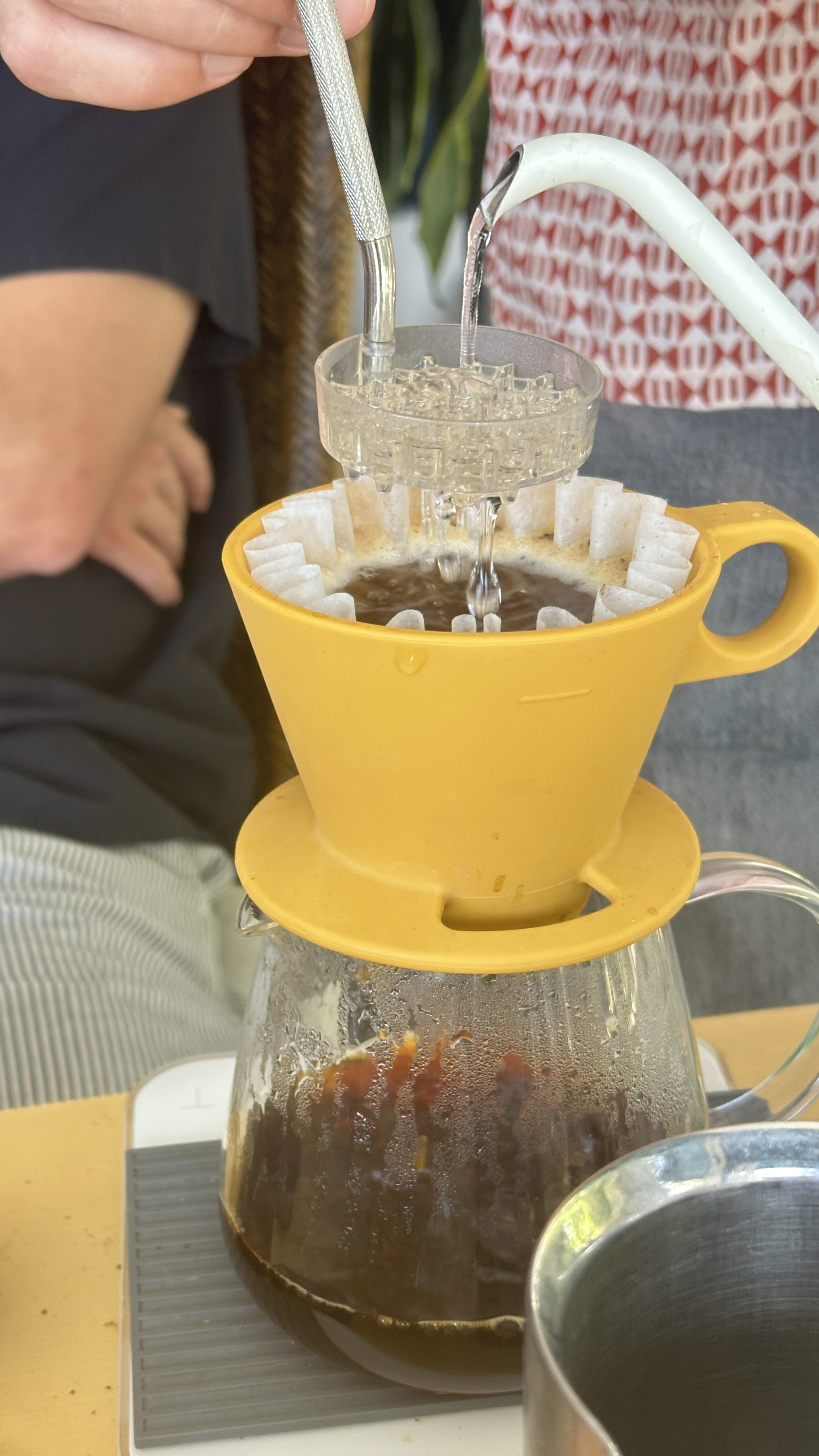 A slow pour-over brewing into a glass carafe